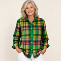 Mature British woman wearing the ELINDRA checked blouse on a clean warm off-white studio background
