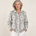 Mature British woman wearing the RENAE blouse on a clean warm off-white studio background